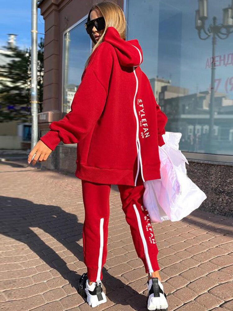 Women wearing an oversized letter print sweatshirt and ankle-length pants tracksuit set, showcasing a stylish and comfortable autumn/winter outfit.