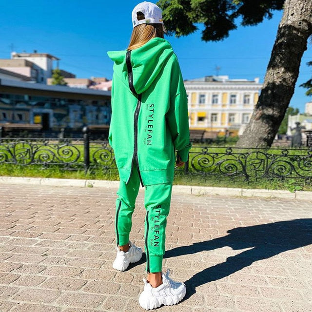 Women wearing an oversized letter print sweatshirt and ankle-length pants tracksuit set, showcasing a stylish and comfortable autumn/winter outfit.