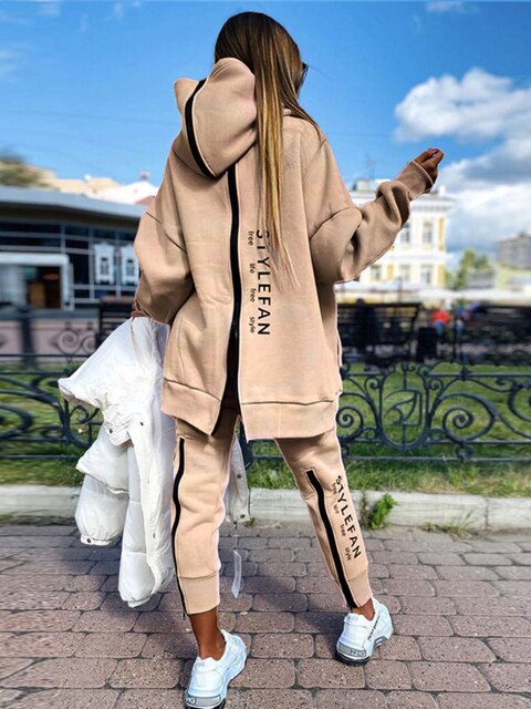 Women wearing an oversized letter print sweatshirt and ankle-length pants tracksuit set, showcasing a stylish and comfortable autumn/winter outfit.