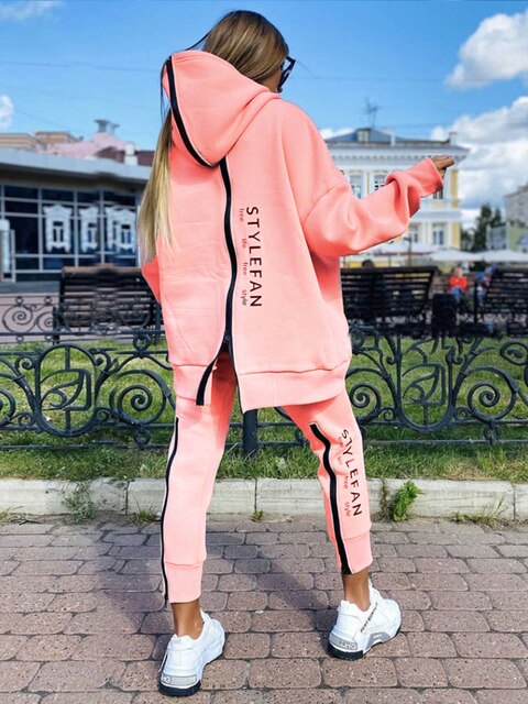 Women wearing an oversized letter print sweatshirt and ankle-length pants tracksuit set, showcasing a stylish and comfortable autumn/winter outfit.