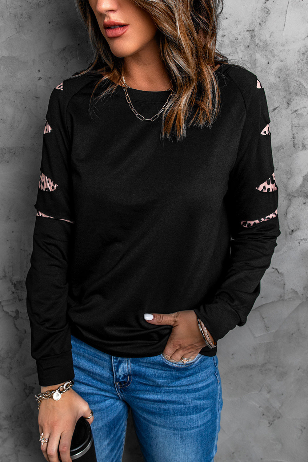 Womens black sweatshirt with leopard insert sleeves, showcasing a stylish and chic design perfect for casual wear.