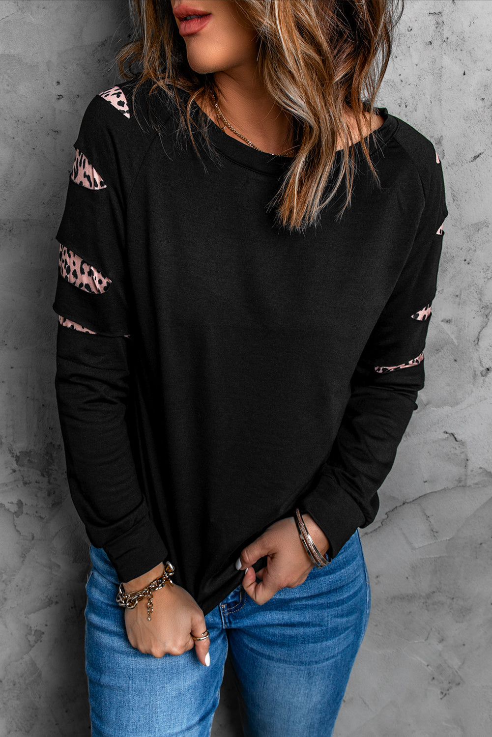 Womens black sweatshirt with leopard insert sleeves, showcasing a stylish and chic design perfect for casual wear.