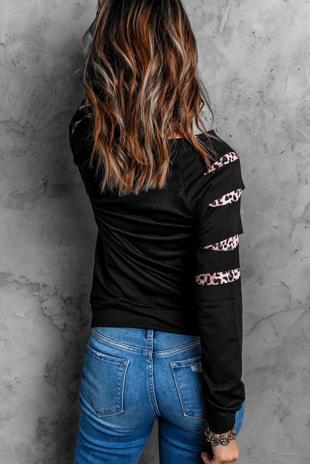 Womens black sweatshirt with leopard insert sleeves, showcasing a stylish and chic design perfect for casual wear.