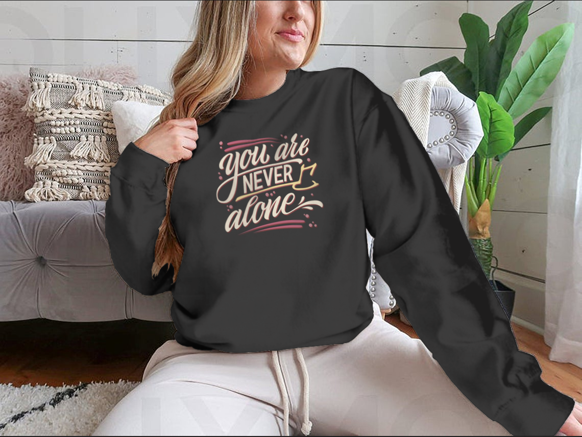 A comfortable cotton t-shirt featuring the hand-drawn lettering phrase 'You Are Never Alone', promoting mental health awareness.