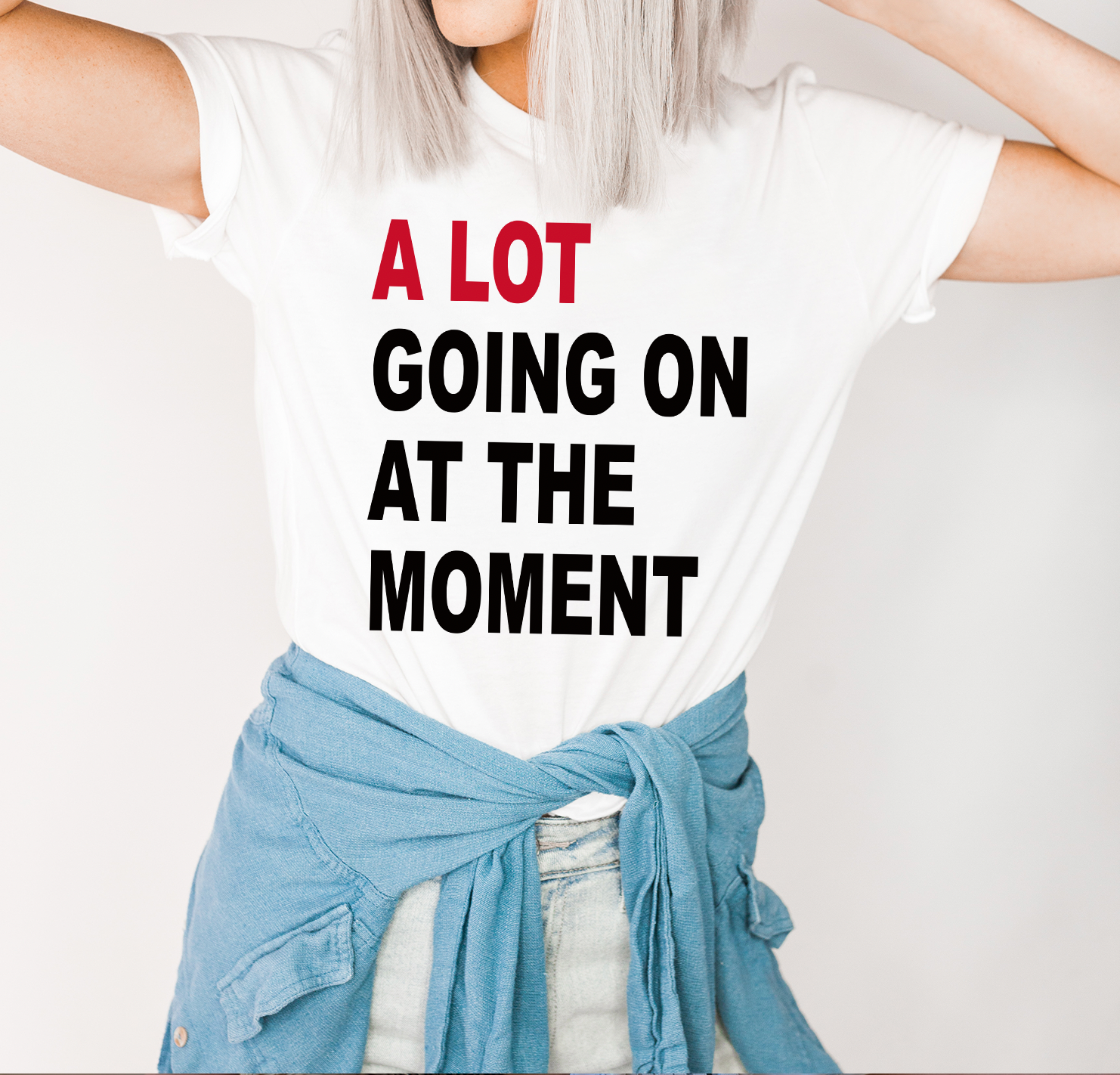 A stylish unisex t-shirt featuring the phrase 'A Lot Going On At The Moment' printed in vibrant colors, showcasing a modern design.