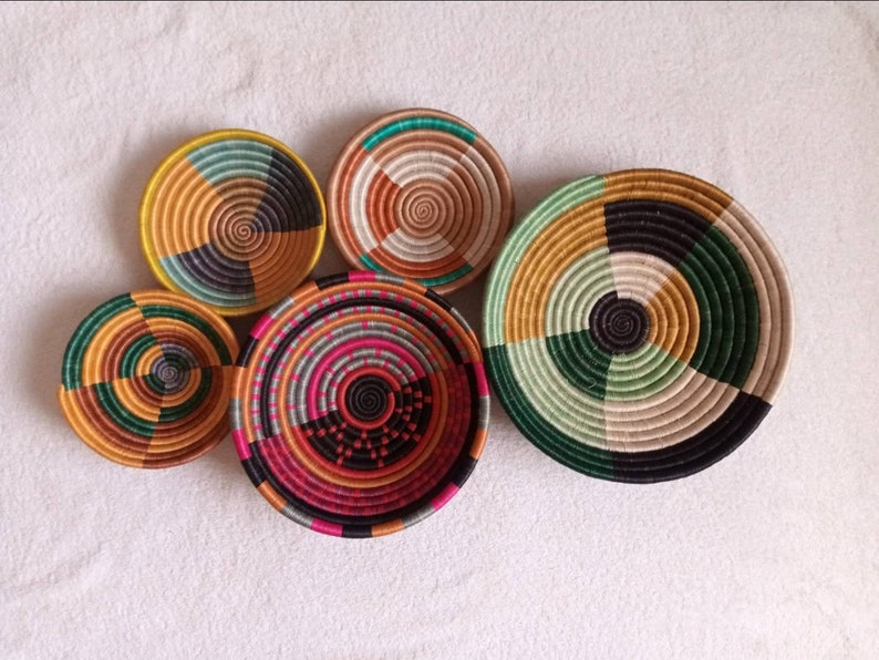 A vibrant set of 5 handwoven African wall baskets made from sisal grass, showcasing unique colors and patterns.