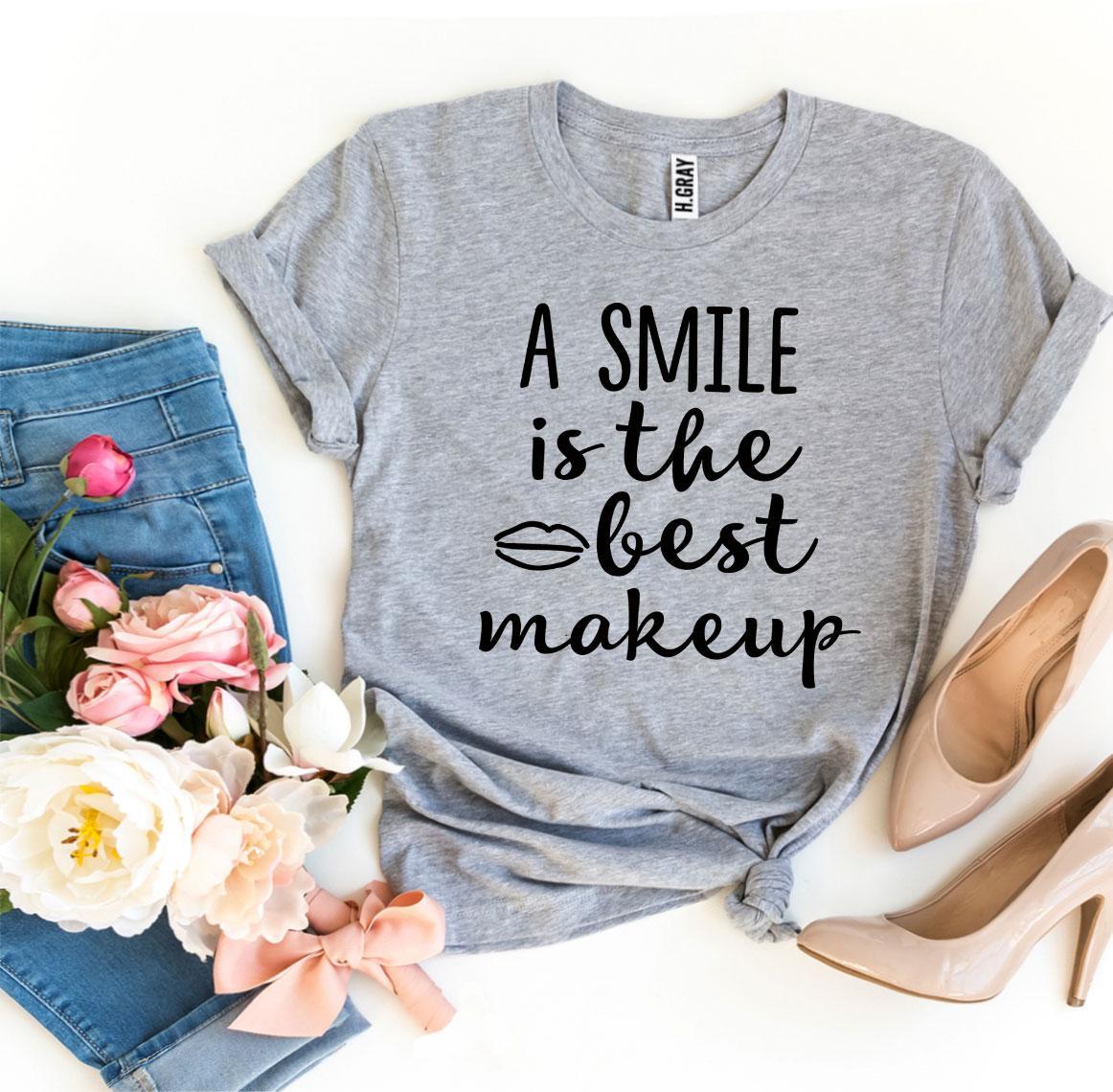 A stylish t-shirt featuring the phrase 'A Smile Is The Best Makeup' printed in vibrant colors on premium cotton fabric.