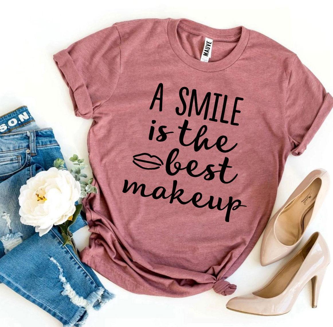 A stylish t-shirt featuring the phrase 'A Smile Is The Best Makeup' printed in vibrant colors on premium cotton fabric.