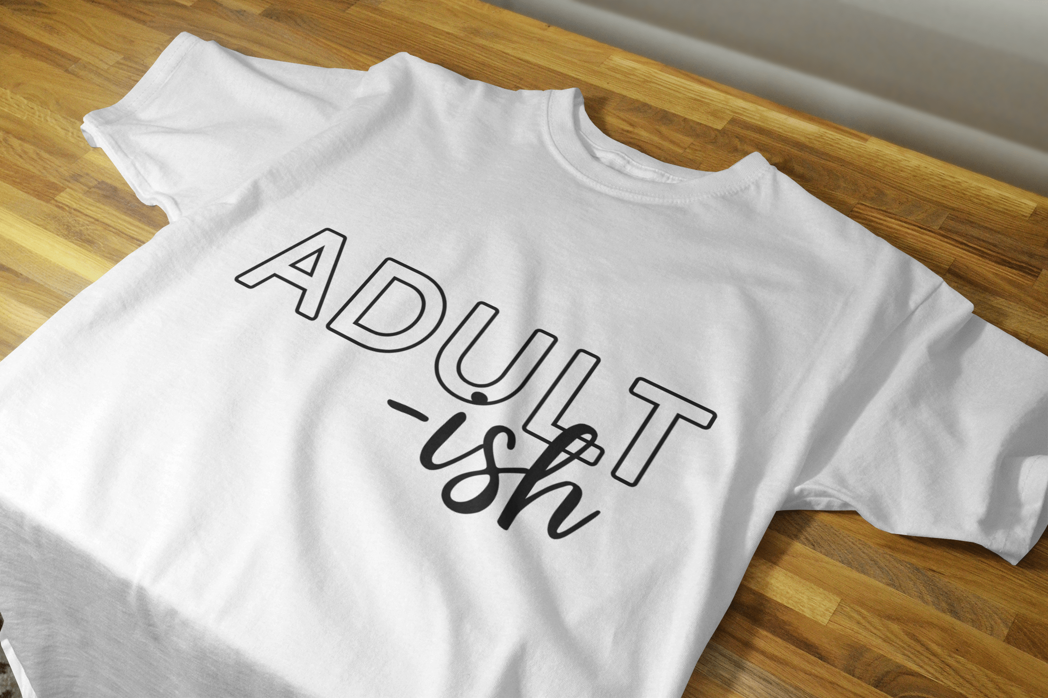 Adult-ish Shirt in black with white lettering, showcasing a classic fit and comfortable design.