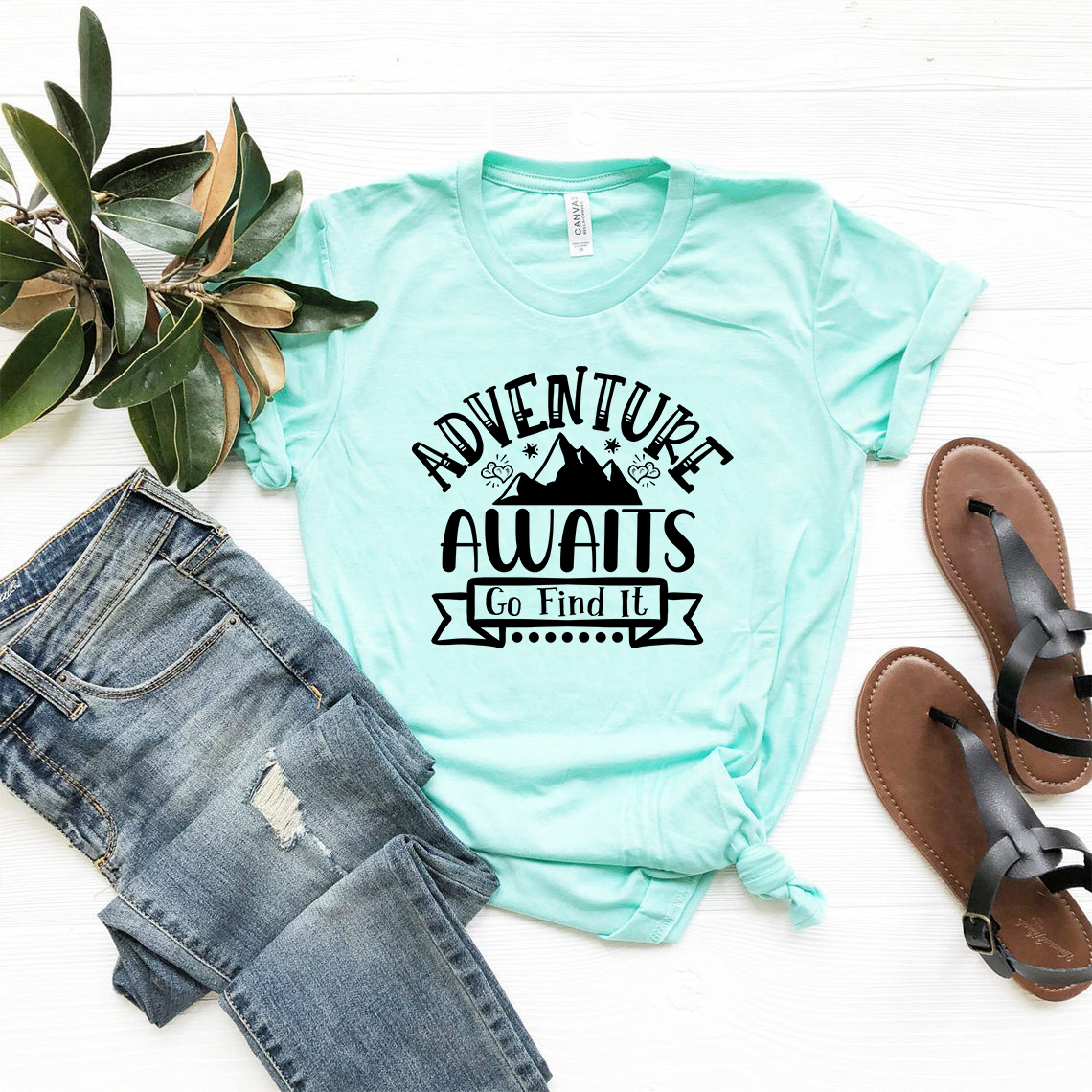 A unisex Adventure Awaits Go Find It T-shirt in various colors, showcasing its comfortable fabric and stylish design.