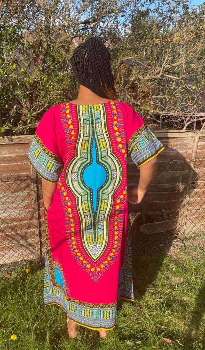 A vibrant pink African Dashiki Dress featuring traditional prints, showcasing its multi kaftan design and comfortable fit.