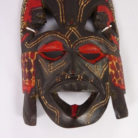 Handcrafted African wooden Kissing Mask featuring two faces and intricate animal patterns, perfect for wall decoration.