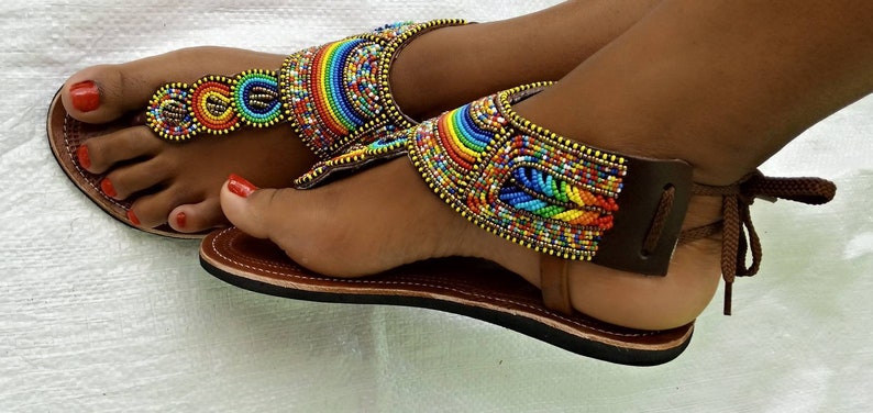 A pair of African Maasai sandals featuring colorful beadwork on soft leather, designed for summer wear with a lightweight rubber sole.