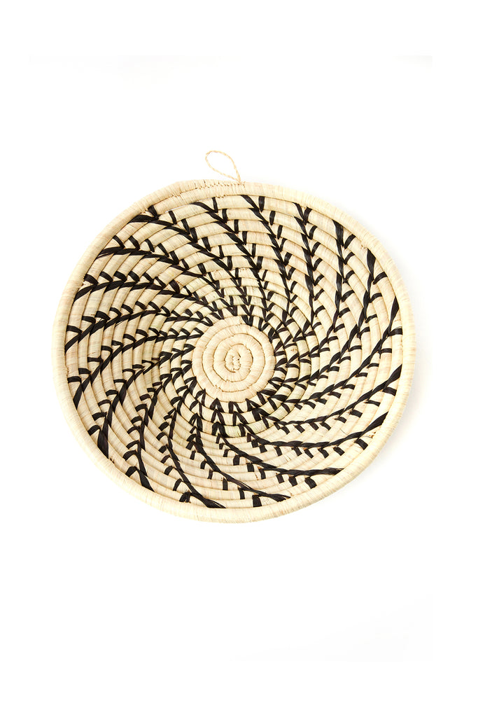 Handcrafted African cream coiled basket with black swirls, showcasing unique design and natural materials.