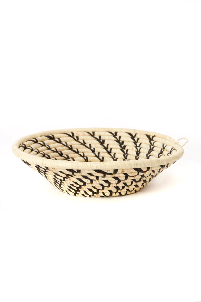 Handcrafted African cream coiled basket with black swirls, showcasing unique design and natural materials.