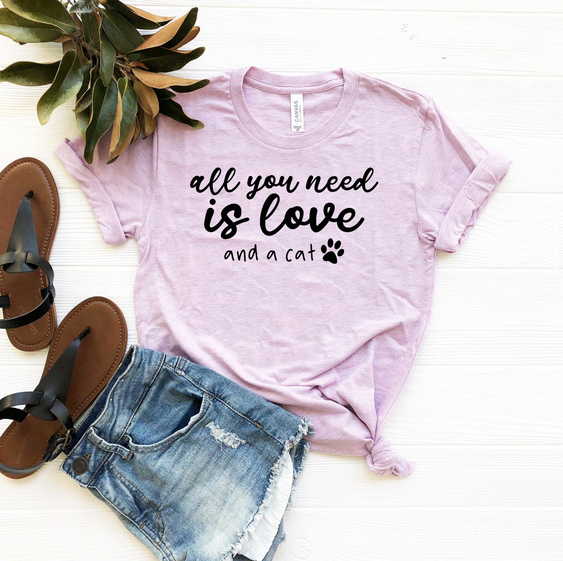 Unisex T-shirt featuring the phrase 'All You Need Is Love And A Cat' in a stylish design, available in multiple colors.