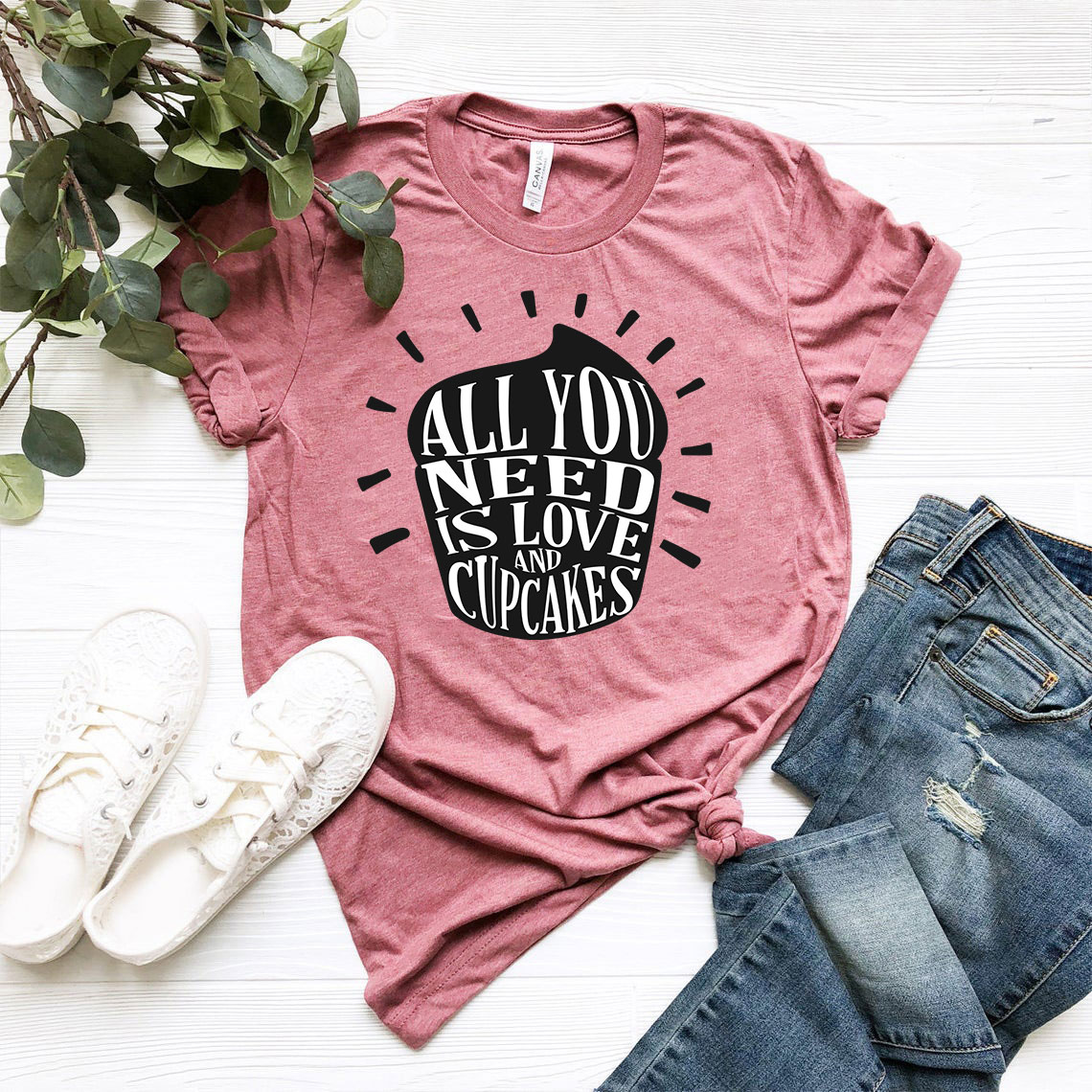 Unisex T-shirt featuring 'All You Need Is Love And Cupcakes' design, available in multiple colors and sizes.