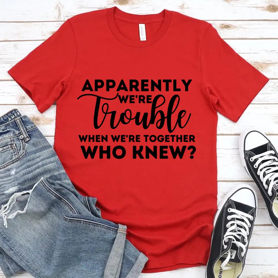 A stylish unisex t-shirt featuring the phrase 'Apparently We're Trouble When We're Together' in a modern font, made from soft Ringspun Cotton.