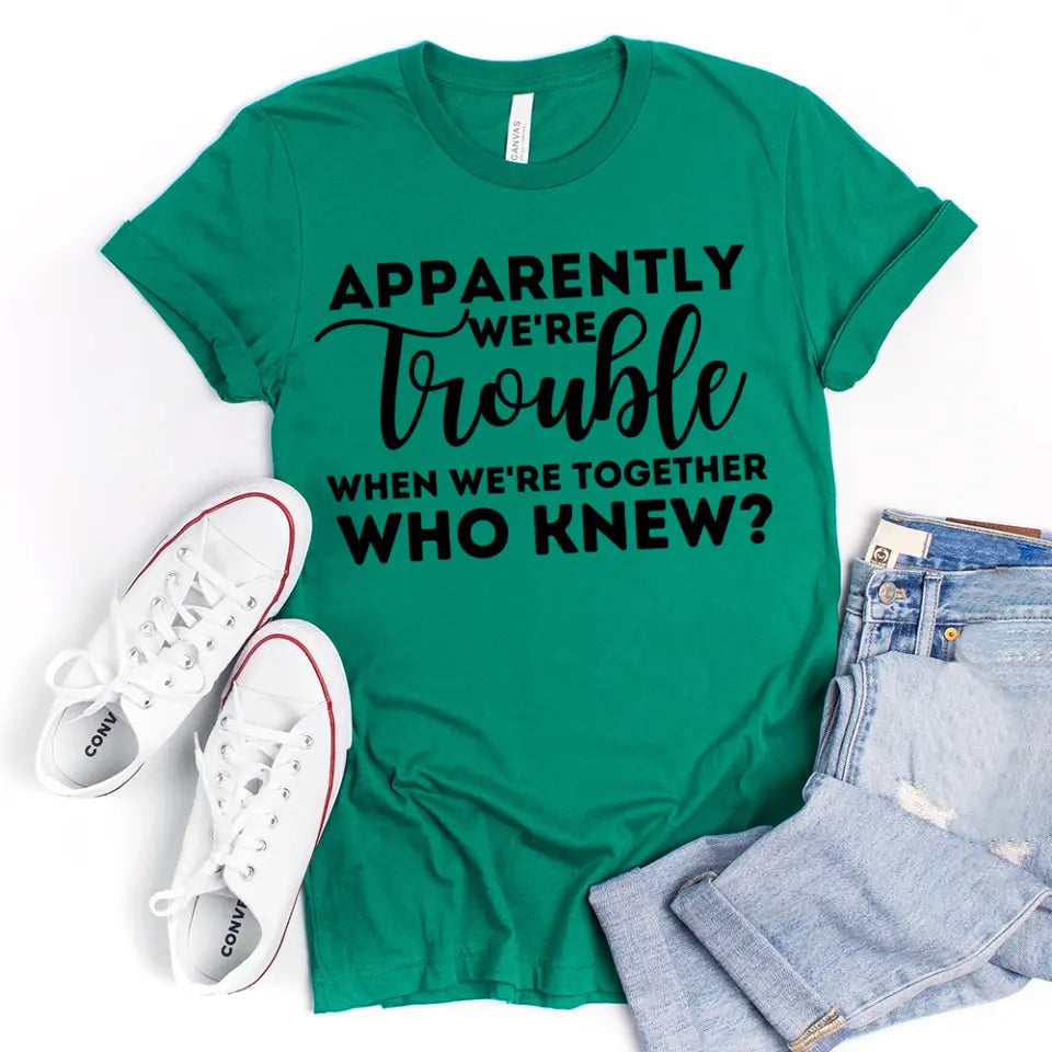 A stylish unisex t-shirt featuring the phrase 'Apparently We're Trouble When We're Together' in a modern font, made from soft Ringspun Cotton.