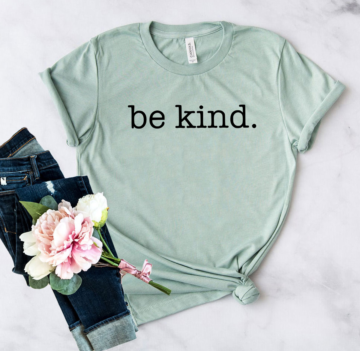 A unisex Be Kind Shirt made from soft ring spun cotton, available in various colors and sizes, featuring a crew neck and short sleeves.