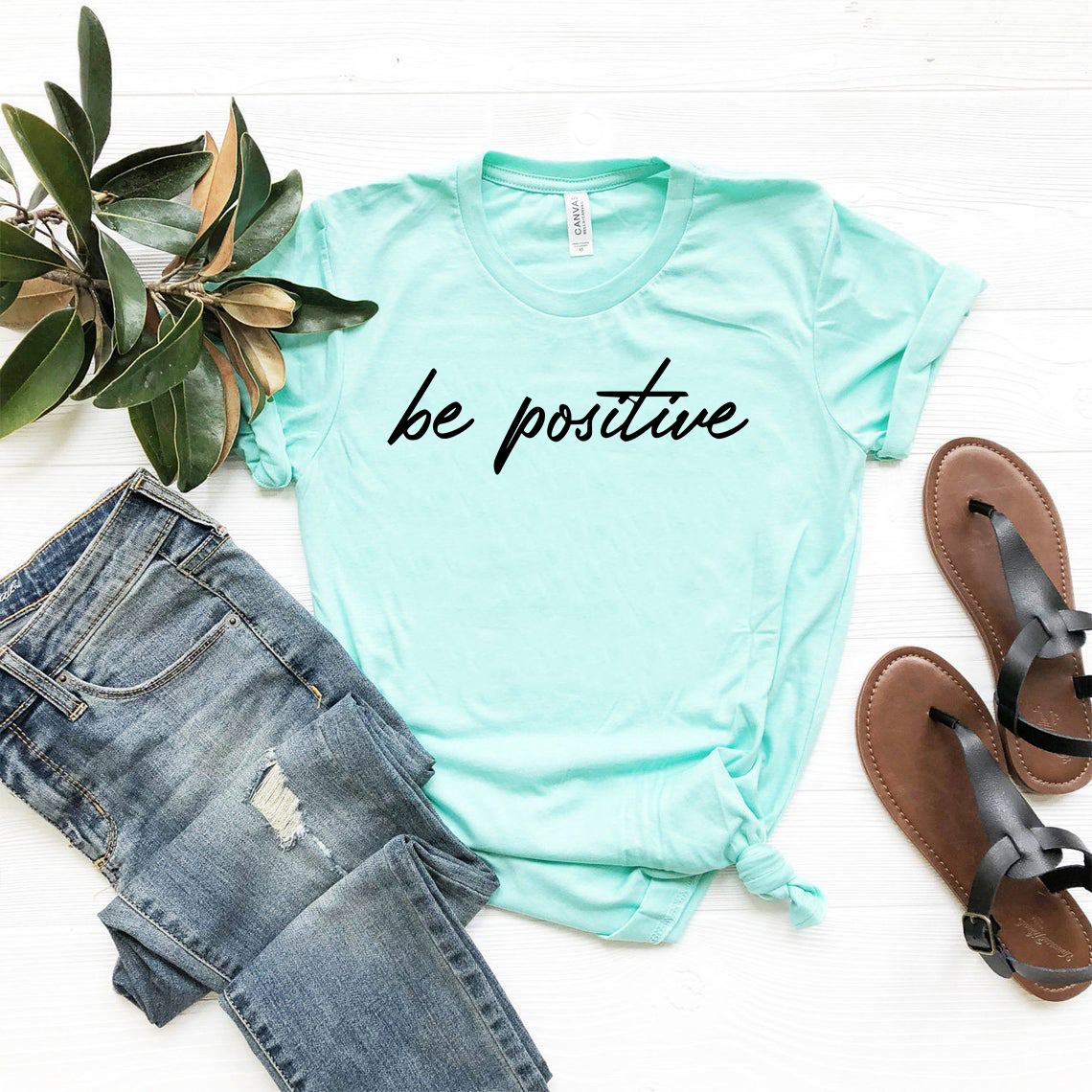 Be Positive Shirt in various colors, showcasing its soft fabric and unisex design.