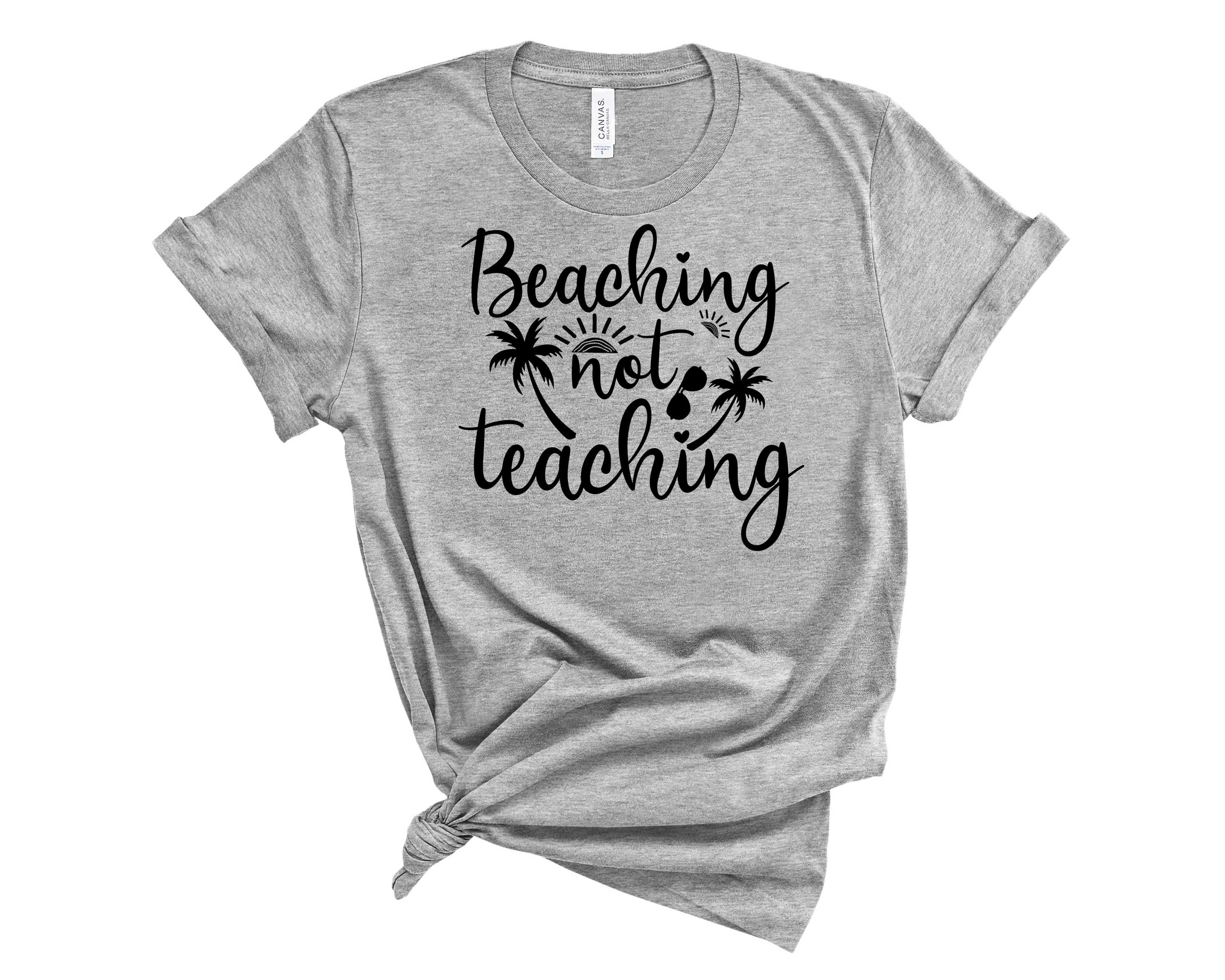 A stylish unisex graphic tee featuring the slogan 'Beaching Not Teaching' in vibrant colors, perfect for casual beach outings.