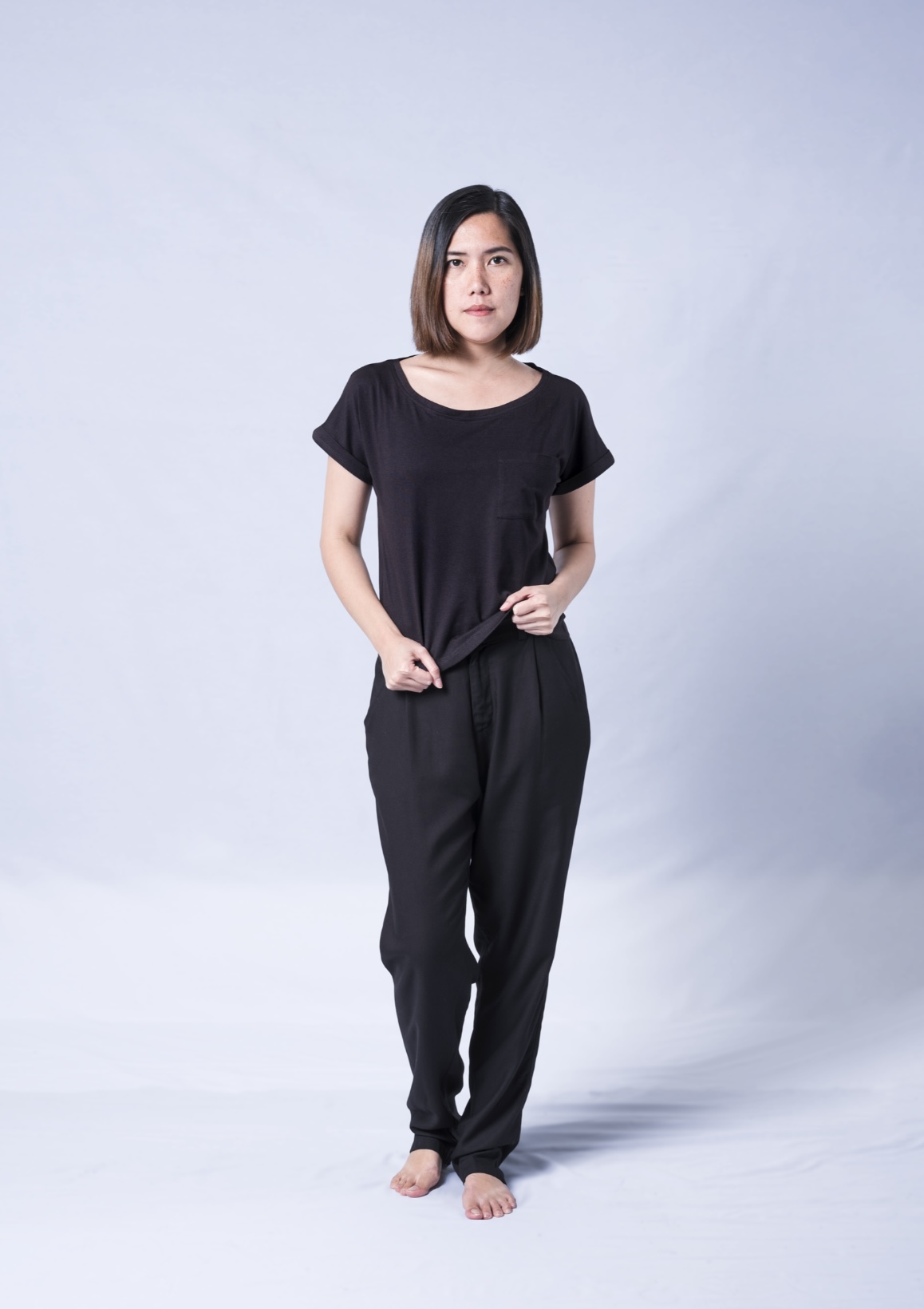 A stylish black t-shirt featuring a wide neck, oversized fit, and rolled sleeves, made from a soft cotton-modal blend.