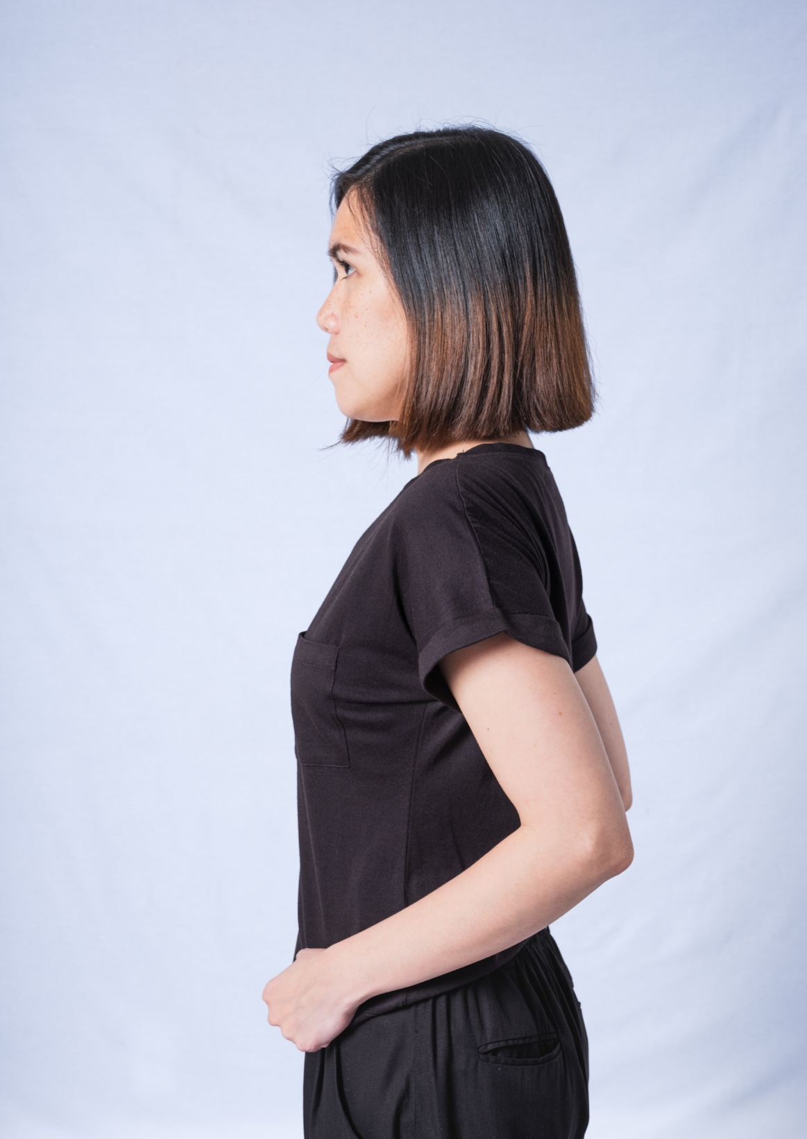 A stylish black t-shirt featuring a wide neck, oversized fit, and rolled sleeves, made from a soft cotton-modal blend.