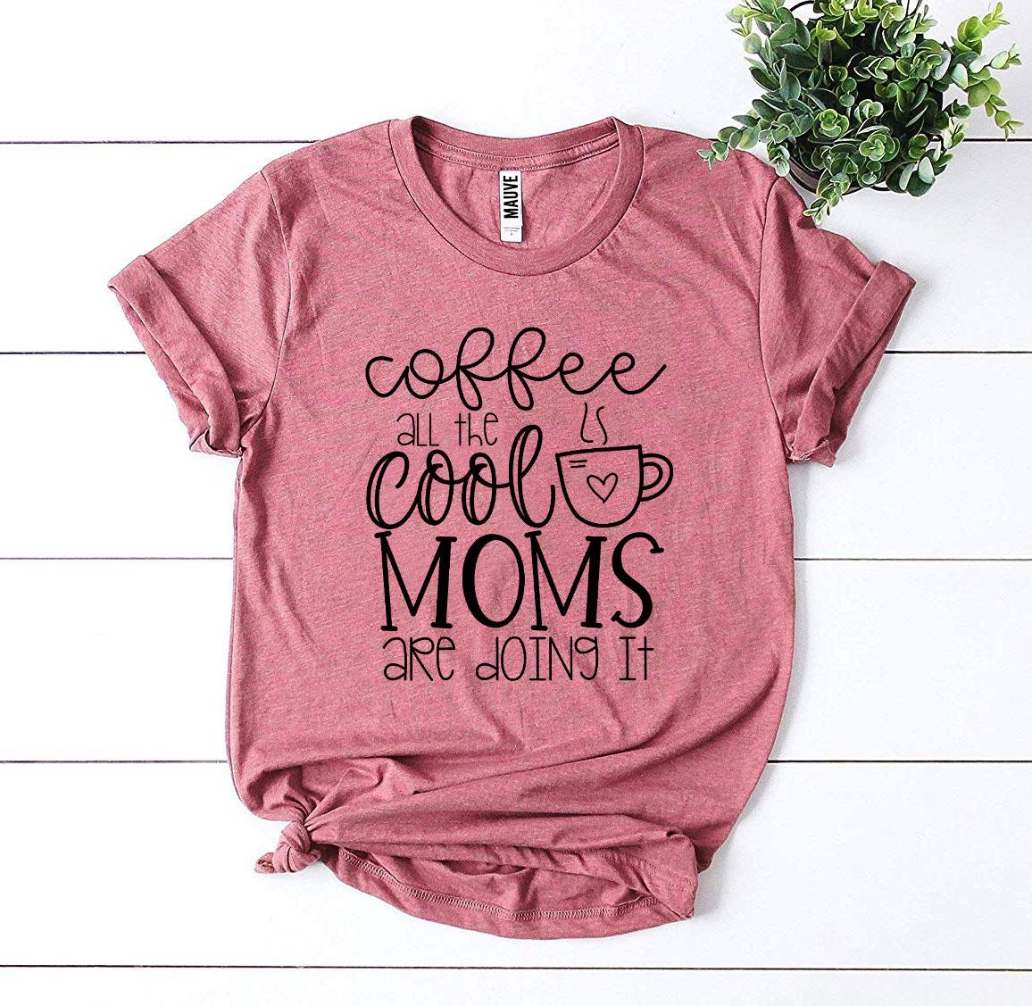 A stylish t-shirt featuring the phrase 'Coffee All The Cool Moms Are Doing It', made from soft ring spun cotton.