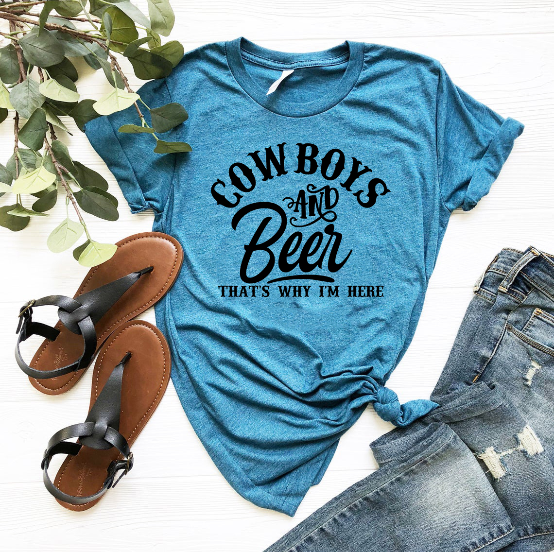 A stylish unisex T-shirt featuring the phrase 'Cow Boys and Beer' in bold print, available in various colors.