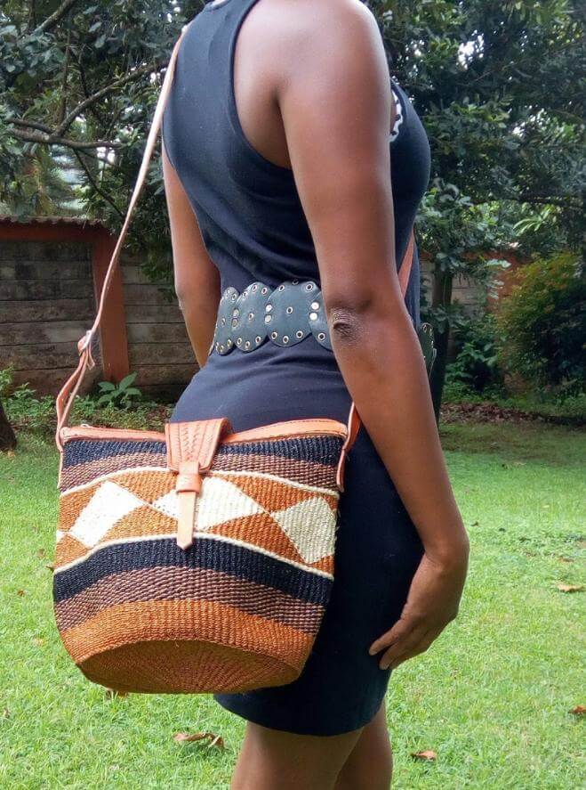 A beautifully handwoven Cross body Kiondo African Bag made from sisal and leather, showcasing intricate patterns and a spacious design.