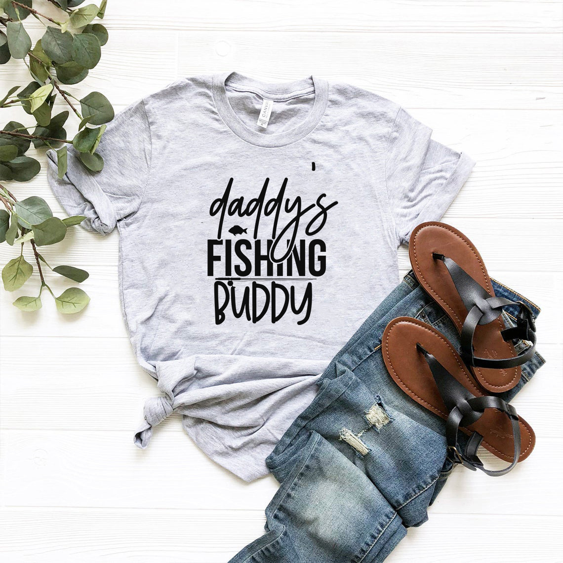 A comfortable unisex T-shirt featuring the phrase 'Daddy's Fishing Buddy' in a stylish print, available in various colors.