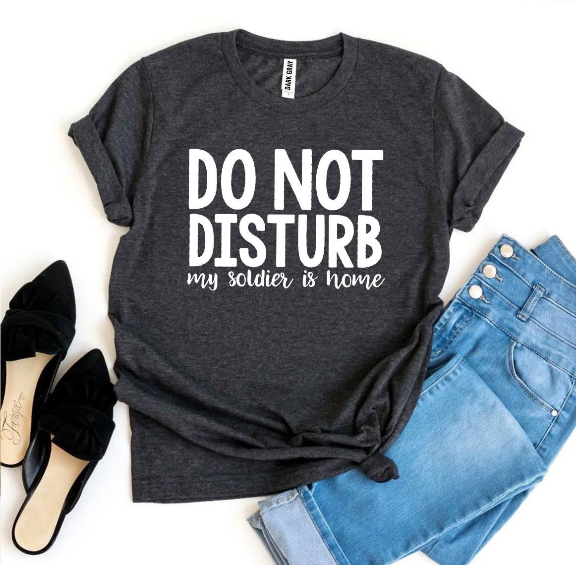 A black T-shirt with the text 'Do Not Disturb My Soldier Is Home' printed in bold letters, showcasing a comfortable and stylish design.