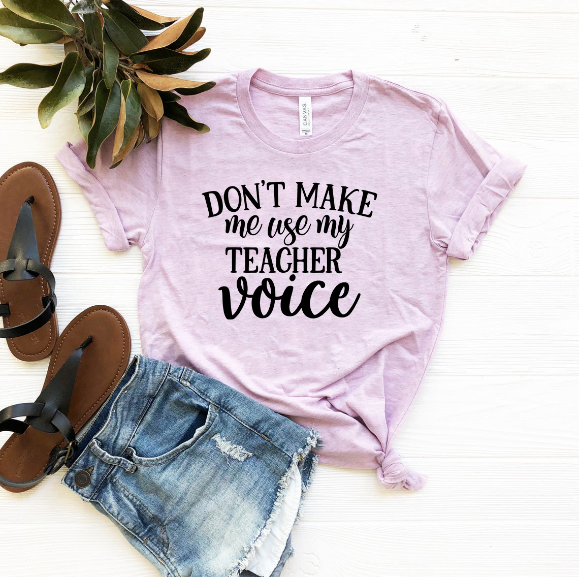 Unisex T-shirt featuring the phrase 'Don't Make Me Use My Teacher Voice' in a stylish design, available in multiple colors.