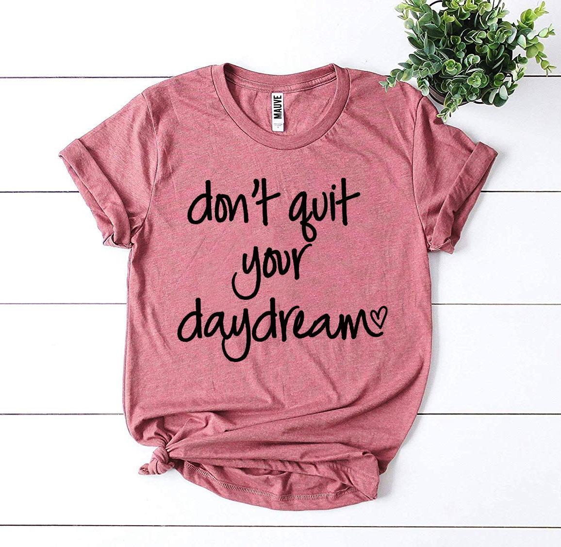 Don’t Quit Your Daydream T-shirt made of premium ring spun cotton with a motivational print, available in various sizes.