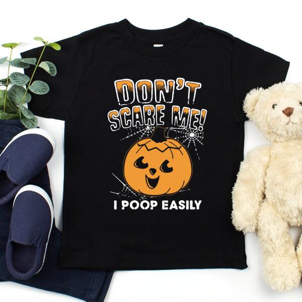 A humorous t-shirt with the phrase 'Don't Scare Me I Poop Easily' printed on it, showcasing a playful design suitable for casual wear.