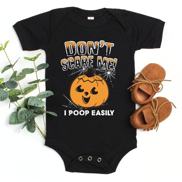 A humorous t-shirt with the phrase 'Don't Scare Me I Poop Easily' printed on it, showcasing a playful design suitable for casual wear.