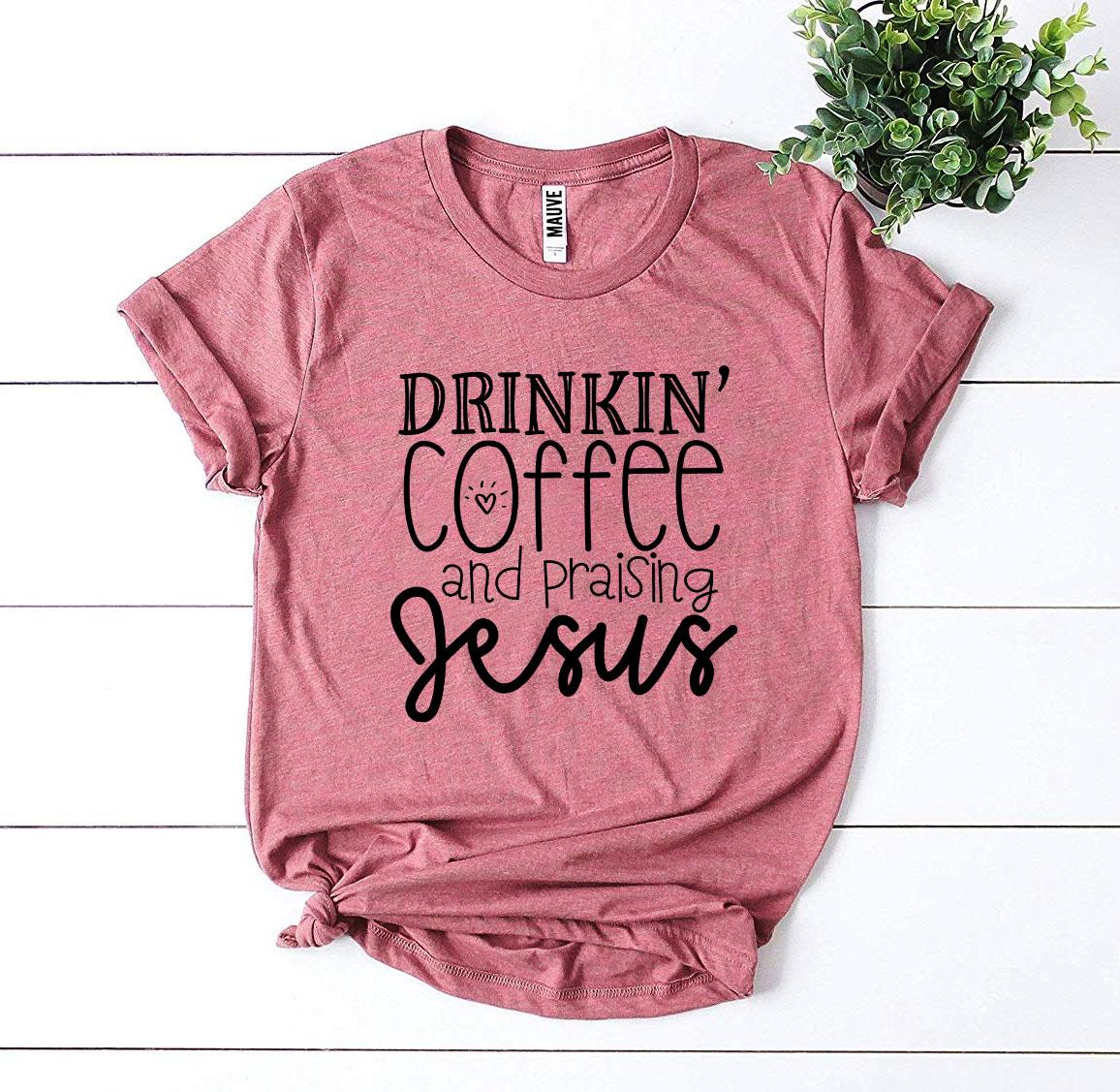 Drinkin’ Coffee And Praising Jesus T-shirt in various sizes, showcasing its soft cotton fabric and vibrant flex print design.