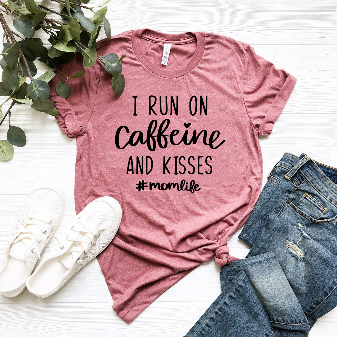 Unisex T-shirt featuring the slogan 'I Run on Caffeine and Kisses' in a vibrant color, made from soft ring spun cotton.