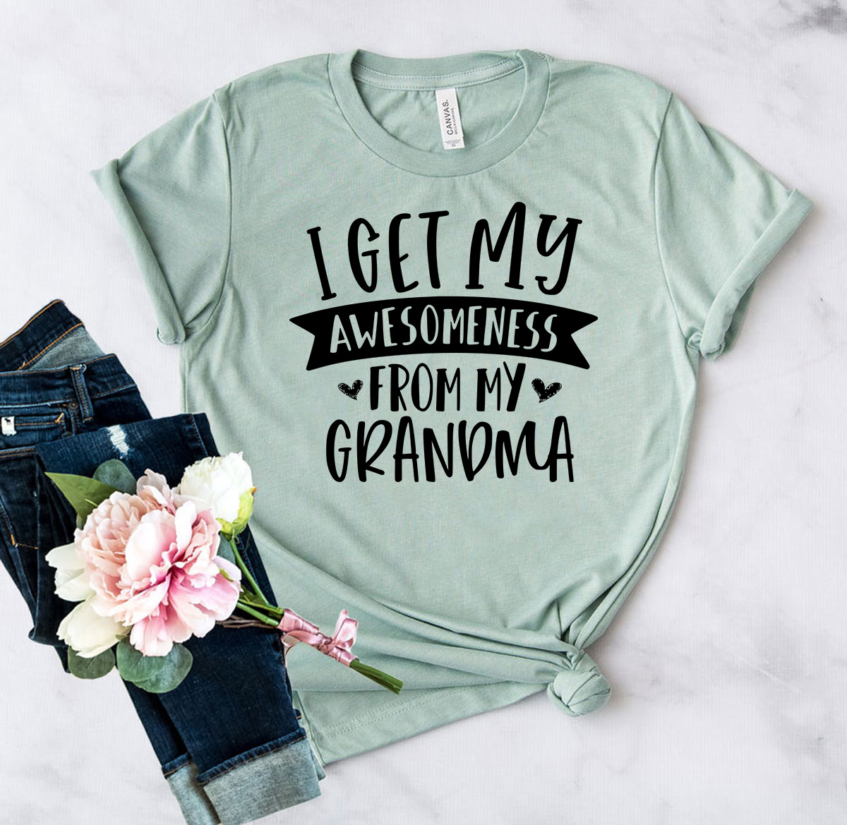 Unisex T-shirt featuring 'I Get Awesomeness from My Grandma' print, made from soft ring spun cotton, available in multiple colors and sizes.