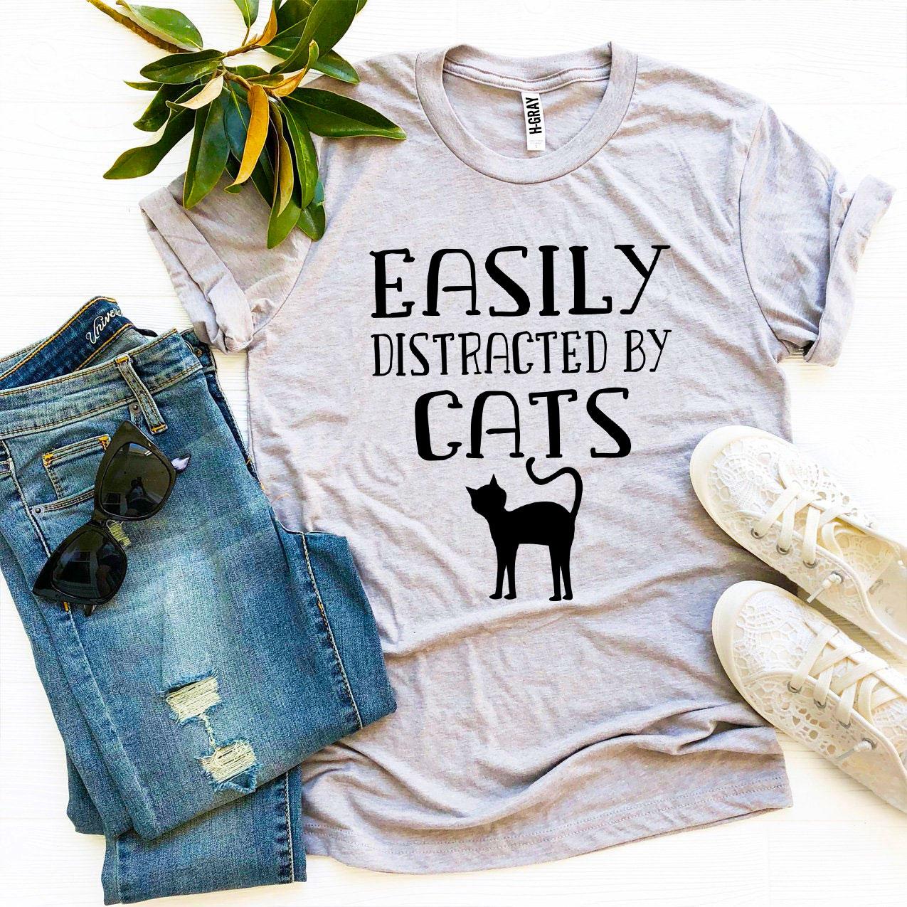 Easily Distracted By Cats T-shirt in various sizes, showcasing its soft cotton fabric and vibrant print design.