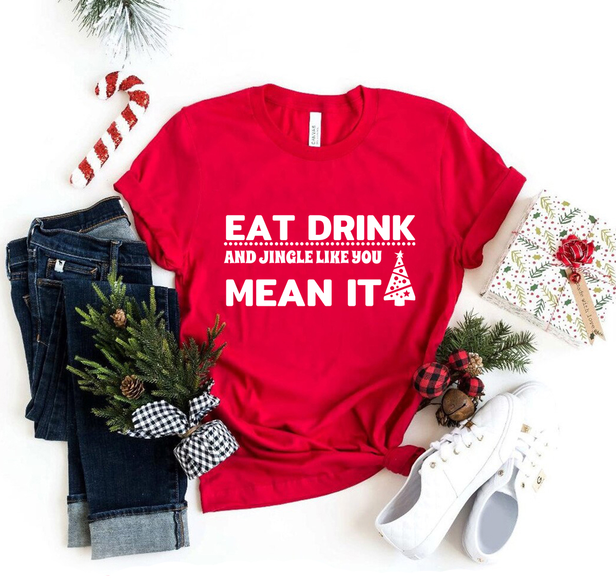 A festive unisex T-shirt featuring the phrase 'Eat Drink And Jingle' in vibrant print, made from soft ring spun cotton.