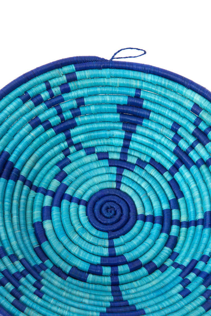 A beautifully handcrafted Ugandan raffia basket made from banana stalks, featuring vibrant colors and a coiled design, perfect for storage or decoration.