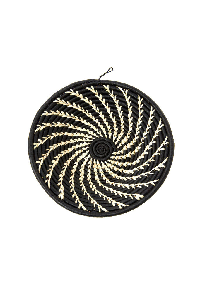 Handwoven African wall basket featuring cream swirls on black raffia, showcasing intricate craftsmanship by Ugandan artisans.