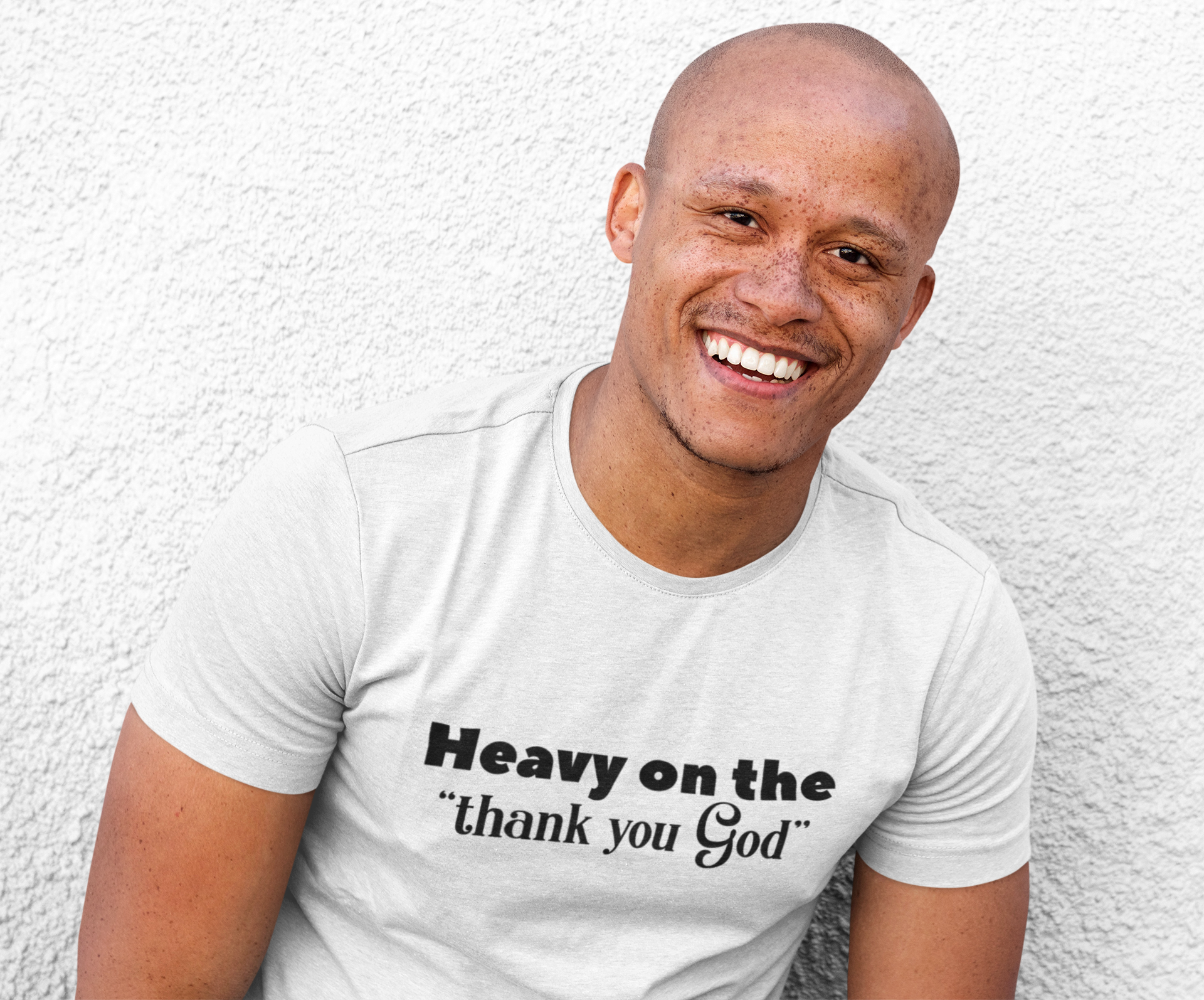 A stylish unisex shirt featuring the phrase 'Heavy On The Thank You God' printed on a soft, 100% cotton fabric.