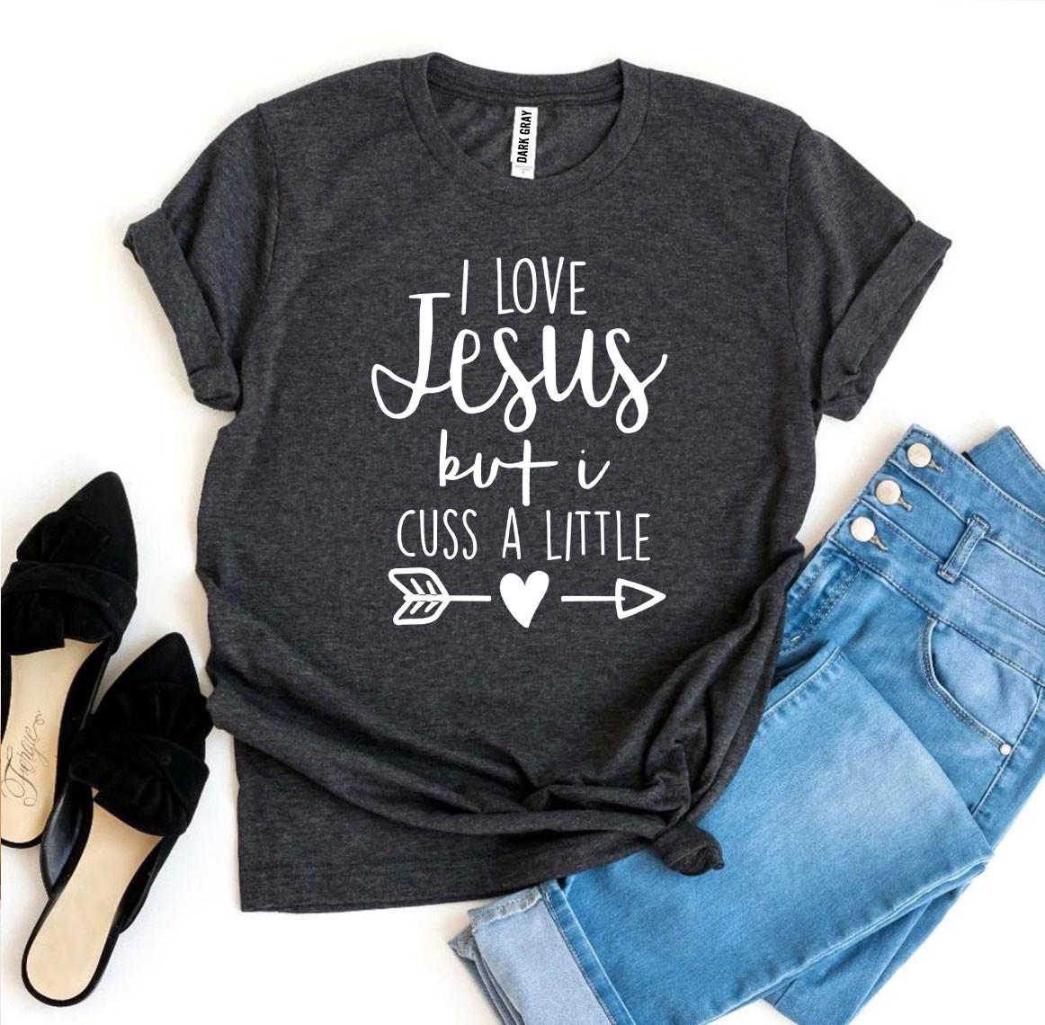 I Love Jesus But I Cuss a Little T-shirt in various sizes, showcasing its soft cotton fabric and humorous design.