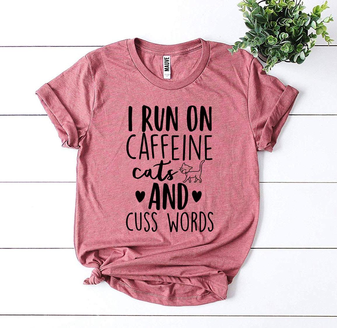 I Run On Caffeine Cats And Cuss Words T-shirt displayed on a mannequin, showcasing its soft fabric and vibrant print.