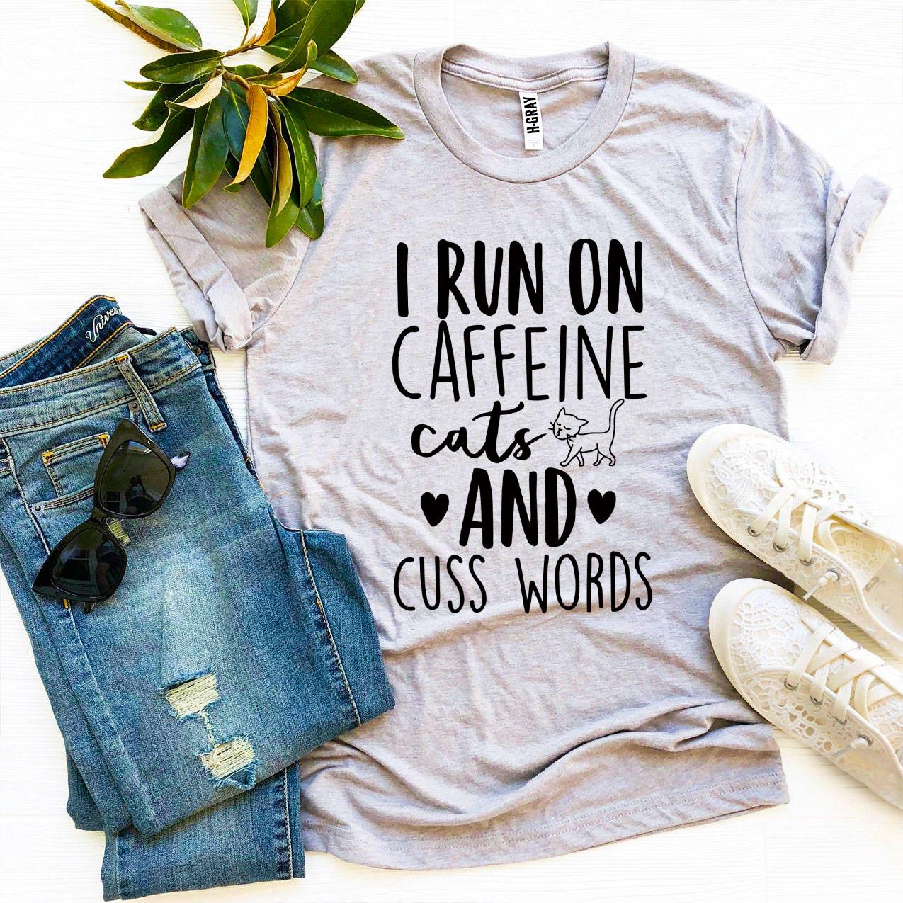 I Run On Caffeine Cats And Cuss Words T-shirt displayed on a mannequin, showcasing its soft fabric and vibrant print.