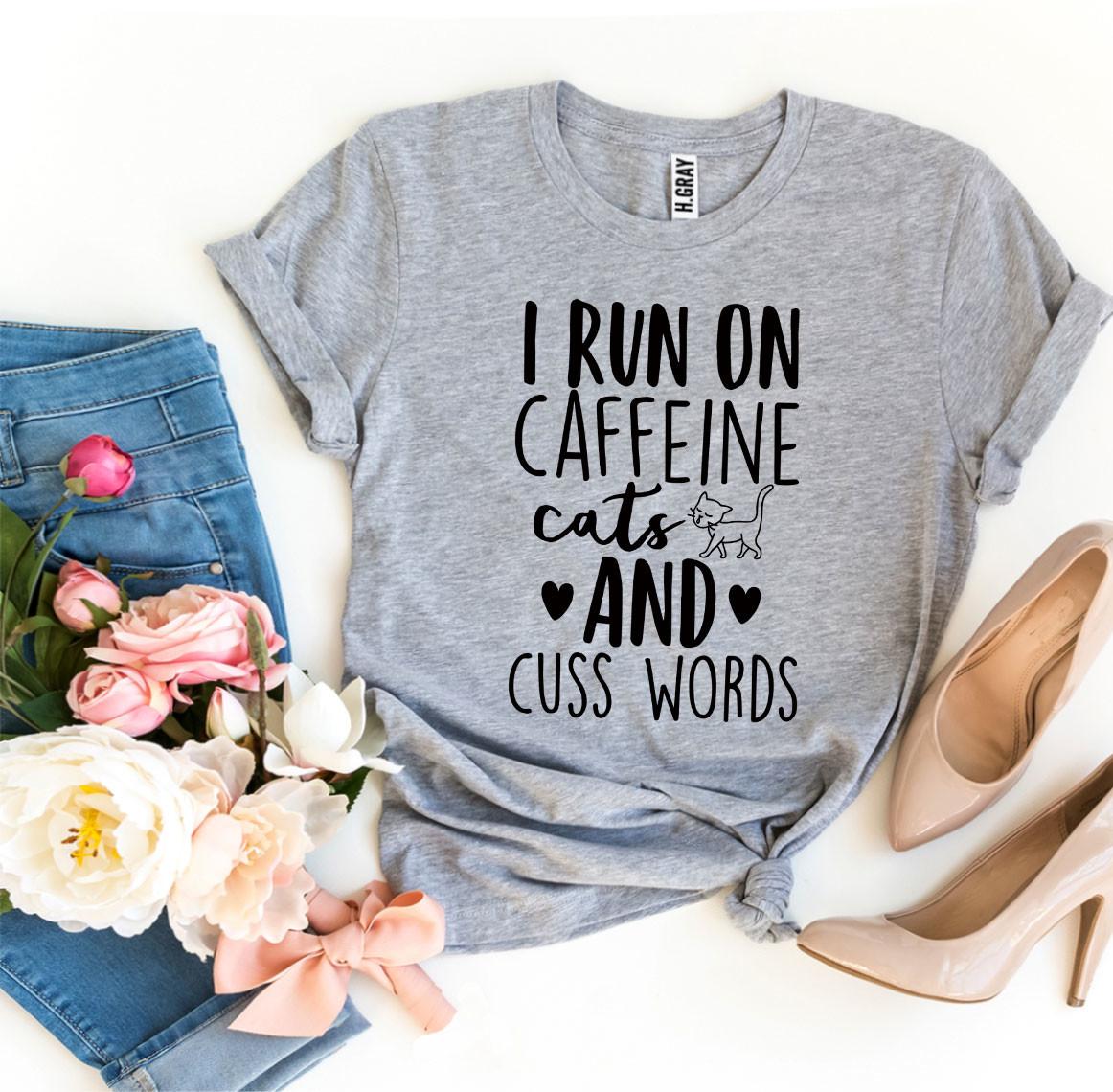 I Run On Caffeine Cats And Cuss Words T-shirt displayed on a mannequin, showcasing its soft fabric and vibrant print.