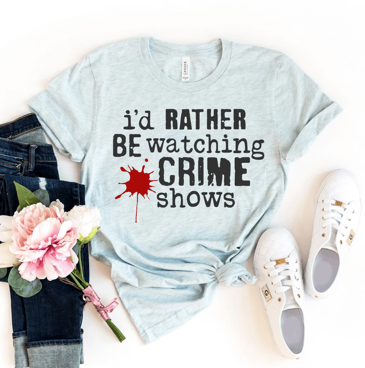 A comfortable t-shirt featuring the phrase 'I'd Rather Be Watching Crime Shows' printed in a stylish design, made from premium ring spun cotton.